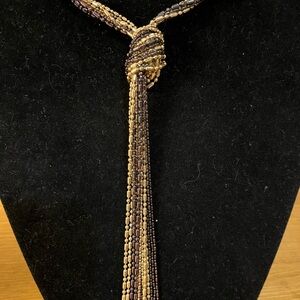 Tassel necklace with 7 bead strands in gold and gun metal ties in knot 36”